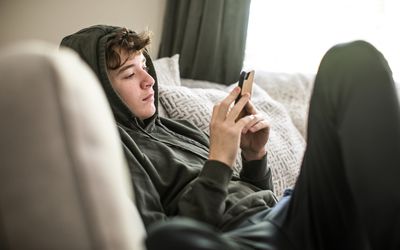 teenage-boy-using-smartphone-at-home-1218225082-6685f04b3f844262b7a31e92c7646baf