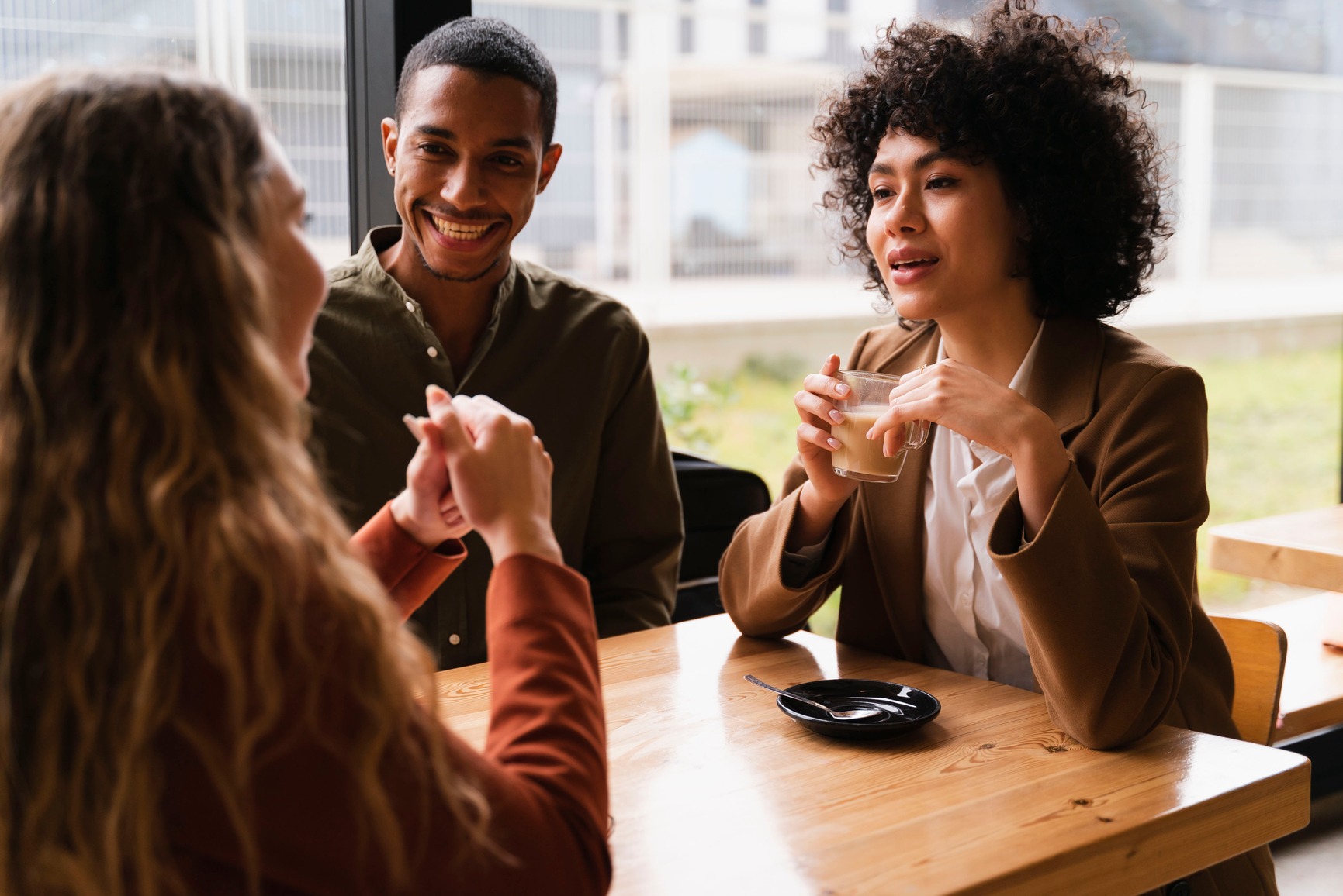 Three-friends-sitting-talking-in-a-cafe